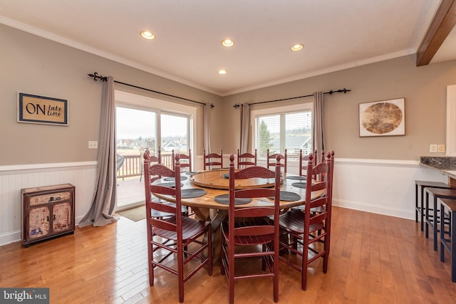 dining space with crown molding and light wood-type flooring