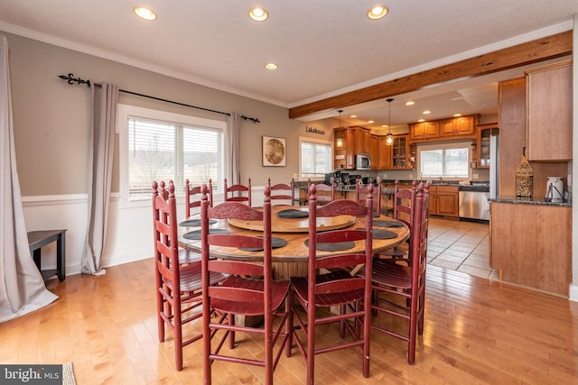 dining room featuring a healthy amount of sunlight, light hardwood / wood-style floors, and crown molding