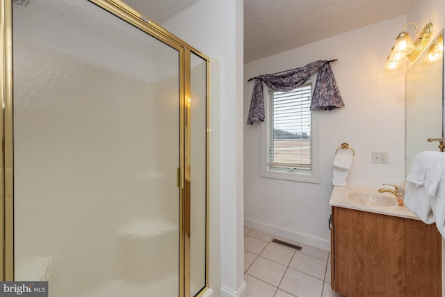 bathroom with tile patterned flooring, a textured ceiling, vanity, and a shower with shower door