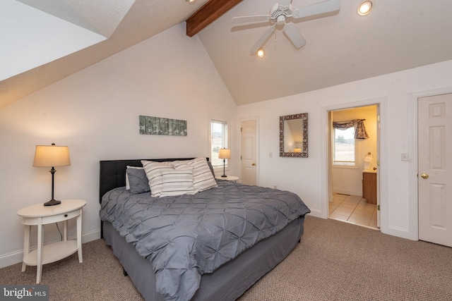 bedroom featuring vaulted ceiling with beams, ceiling fan, ensuite bathroom, and light carpet