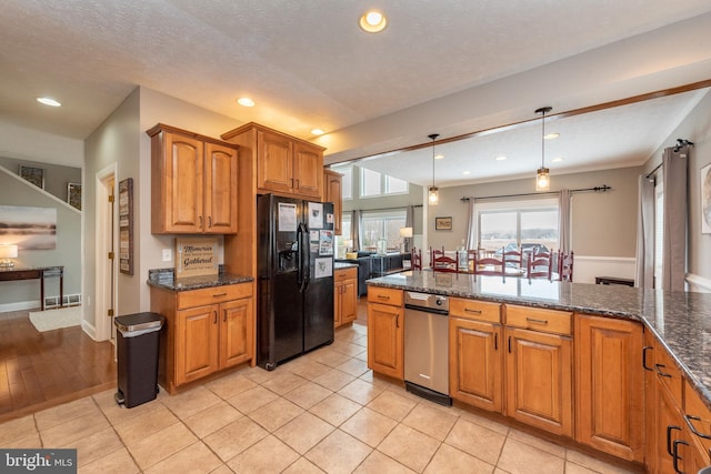 kitchen with black refrigerator with ice dispenser, light tile patterned floors, dark stone counters, and decorative light fixtures