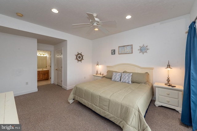 carpeted bedroom with a textured ceiling, connected bathroom, and ceiling fan