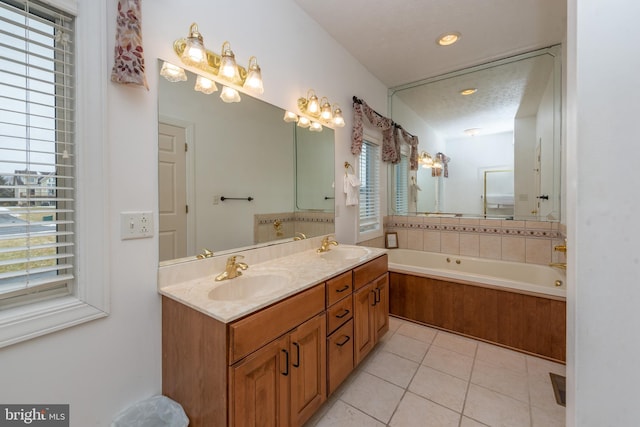 bathroom featuring vanity, a textured ceiling, tile patterned floors, and a bathtub