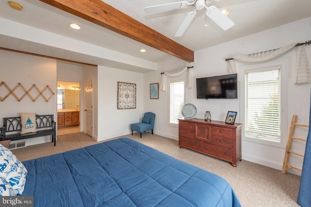 bedroom featuring light carpet, ensuite bathroom, ceiling fan, multiple windows, and beamed ceiling