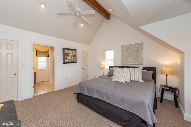 bedroom featuring vaulted ceiling with beams, ceiling fan, ensuite bath, and multiple windows