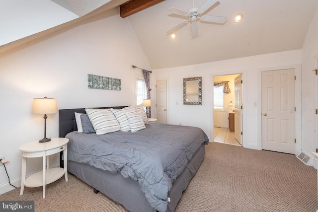 bedroom featuring light colored carpet, ceiling fan, high vaulted ceiling, beamed ceiling, and connected bathroom