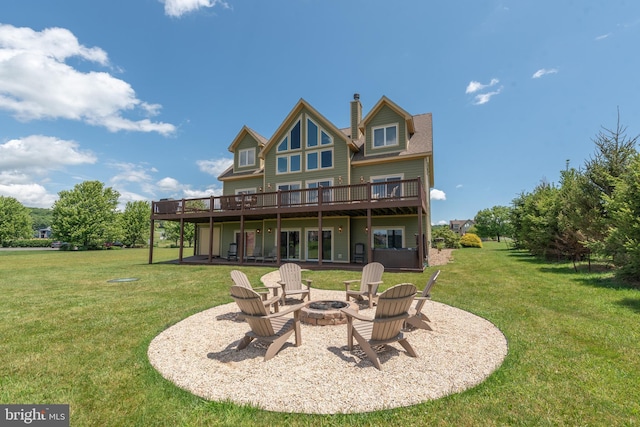 back of property featuring a lawn, a wooden deck, a patio, and a fire pit