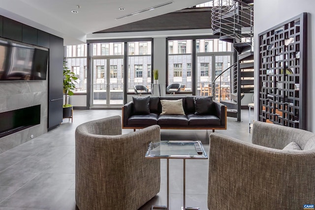 living room featuring a high end fireplace and a healthy amount of sunlight