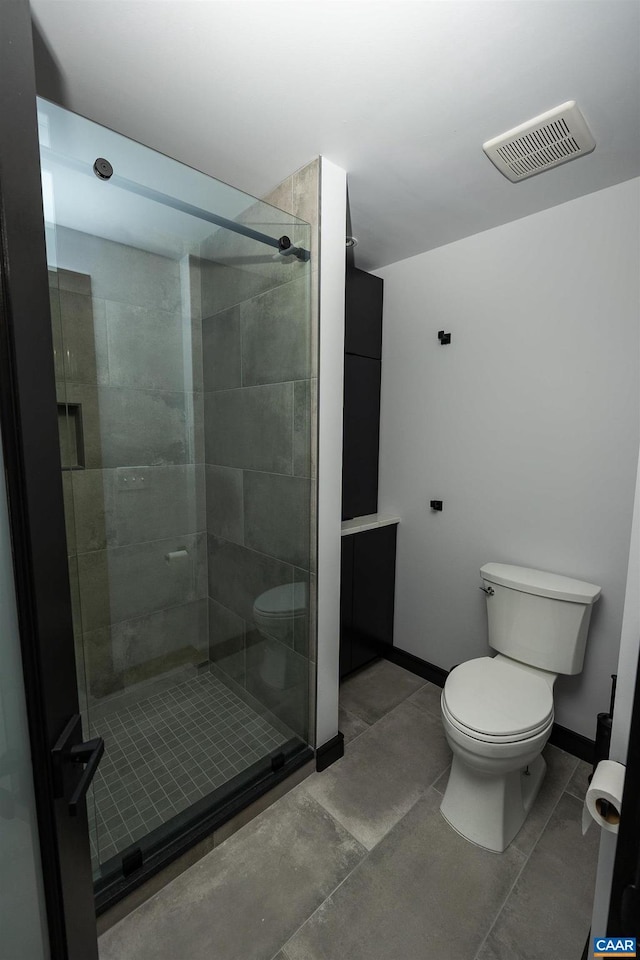 bathroom with toilet and a shower with door