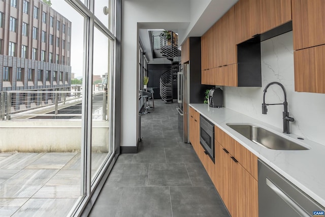 kitchen featuring light stone counters, sink, and appliances with stainless steel finishes