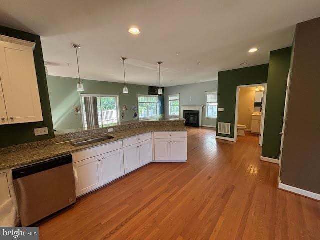 kitchen with white cabinetry, hanging light fixtures, dishwasher, and stone counters