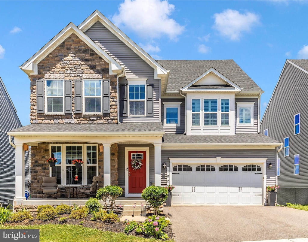 craftsman inspired home featuring a garage and a porch