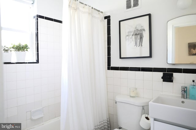 full bathroom featuring shower / tub combo with curtain, vanity, tile walls, and toilet