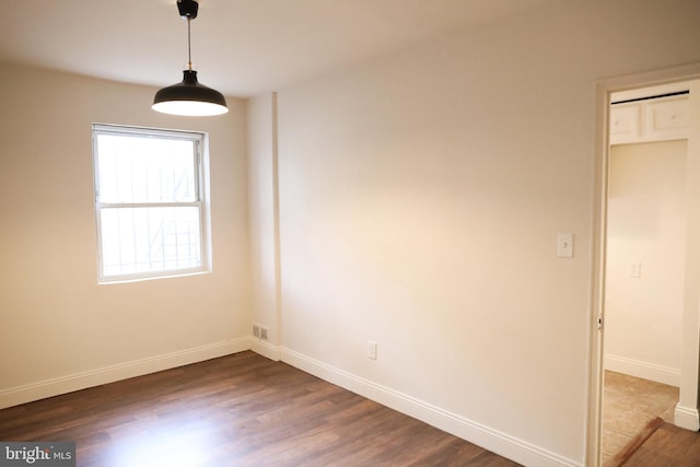 empty room with dark hardwood / wood-style flooring