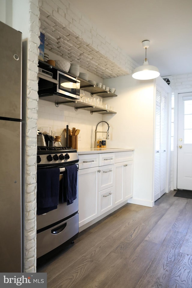 kitchen with white cabinets, sink, tasteful backsplash, wood-type flooring, and stainless steel appliances