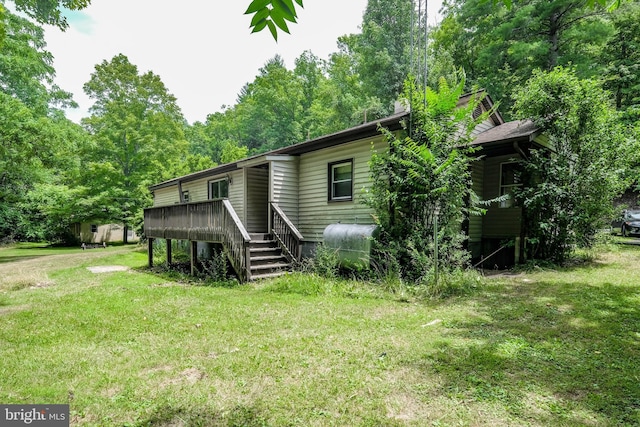 back of property featuring a deck and a lawn