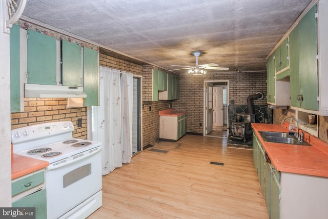 kitchen with a wood stove, sink, white electric range, brick wall, and light wood-type flooring