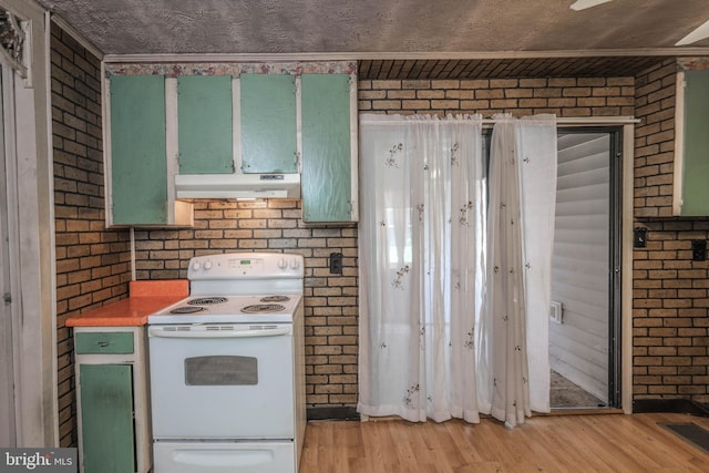 kitchen with light hardwood / wood-style flooring, white range with electric stovetop, and brick wall