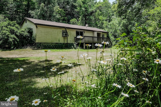 view of front facade featuring a deck and a front lawn