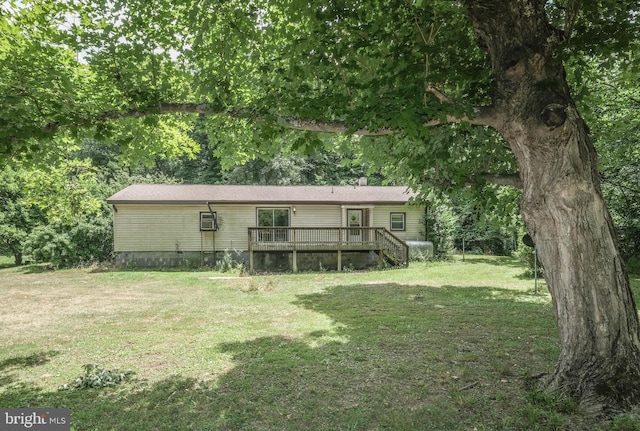 back of house featuring a lawn and a deck