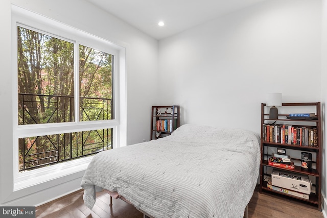 bedroom with dark wood-type flooring and multiple windows