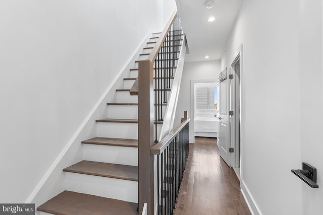 stairway with dark hardwood / wood-style flooring