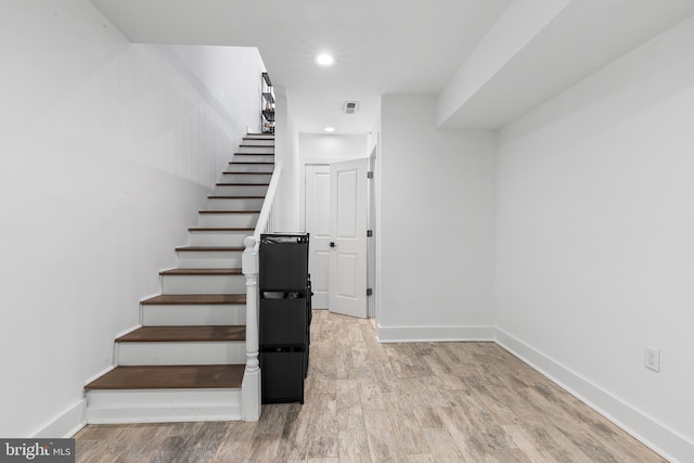 stairs featuring light wood-type flooring