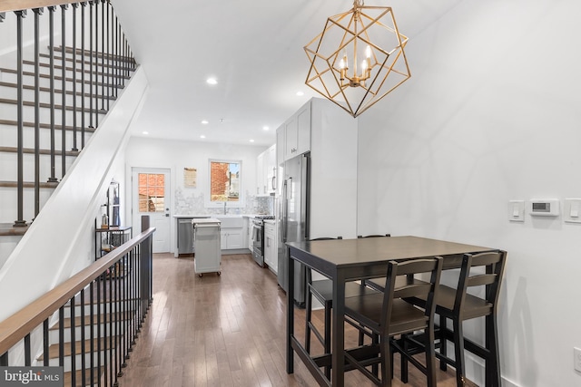 dining area with a chandelier, sink, and dark hardwood / wood-style flooring