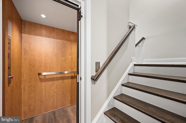 stairs featuring elevator and hardwood / wood-style floors