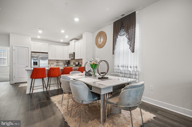 dining space with dark hardwood / wood-style flooring