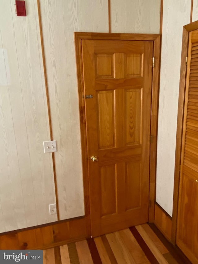 interior space with hardwood / wood-style floors and wooden walls