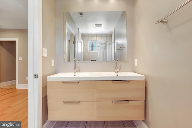 bathroom with a shower with curtain, vanity, and wood-type flooring