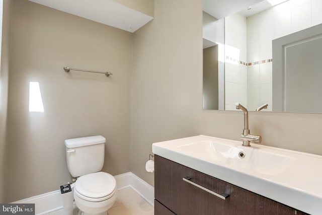 bathroom with tile patterned flooring, vanity, and toilet