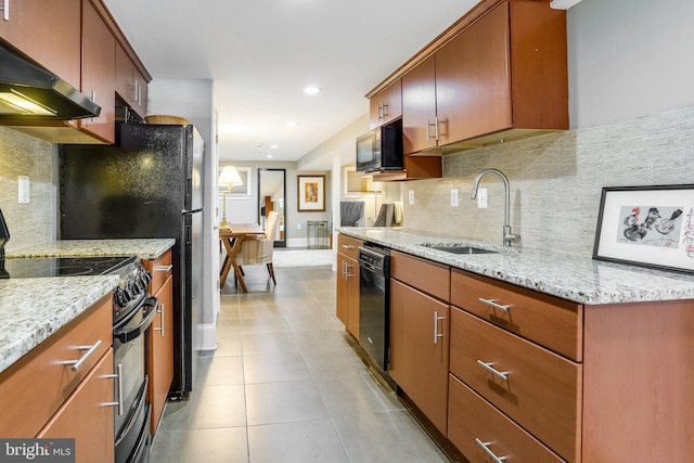 kitchen featuring decorative backsplash, light stone countertops, ventilation hood, sink, and black appliances