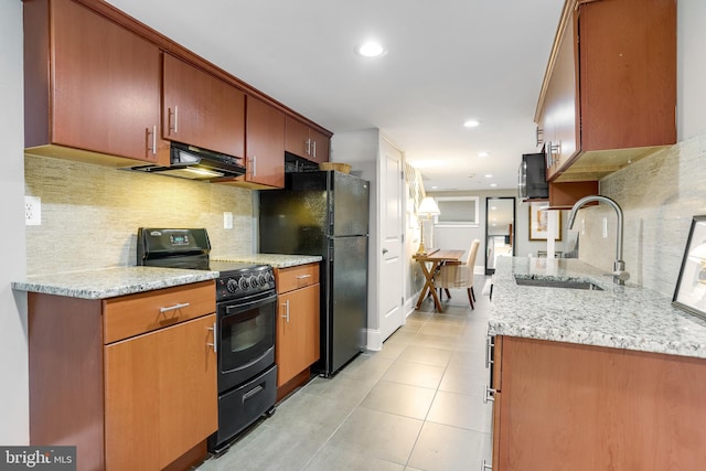 kitchen with light stone countertops, sink, backsplash, light tile patterned floors, and black appliances