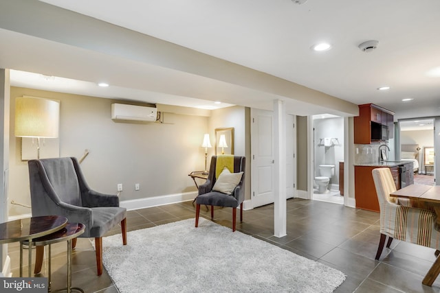 sitting room featuring a wall unit AC, sink, and dark tile patterned flooring