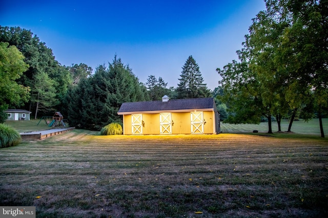 rear view of house with a lawn and an outbuilding