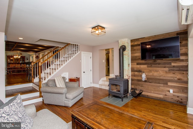 living room featuring wooden walls, hardwood / wood-style flooring, and a wood stove