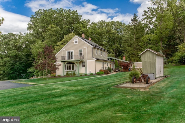 view of property exterior with a lawn and a storage shed