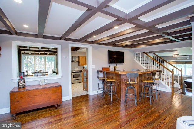 bar with beam ceiling, stainless steel stove, and hardwood / wood-style flooring