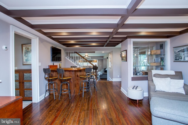 dining room with beam ceiling, indoor bar, dark wood-type flooring, and coffered ceiling