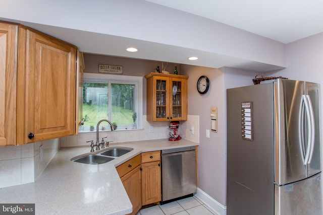 kitchen with sink, stainless steel appliances, light tile patterned flooring, and decorative backsplash