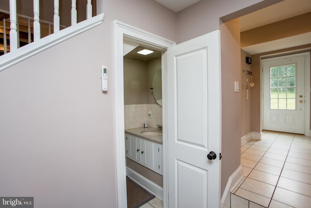 hall with sink and light tile patterned floors