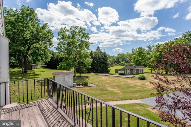 wooden terrace with an outdoor structure and a lawn