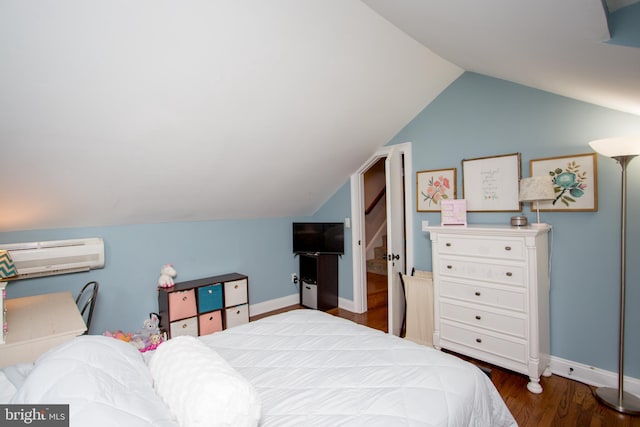 bedroom with vaulted ceiling, dark hardwood / wood-style flooring, and a wall unit AC