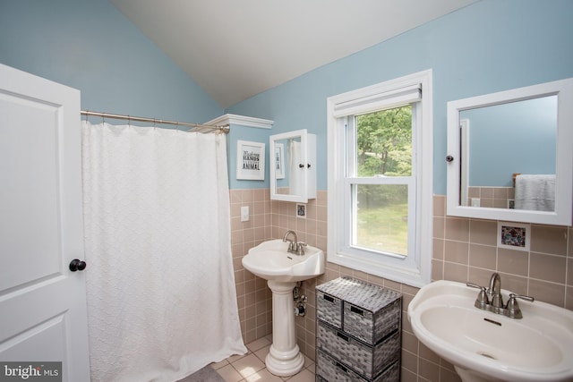 bathroom with tile walls, tile patterned flooring, plenty of natural light, and lofted ceiling