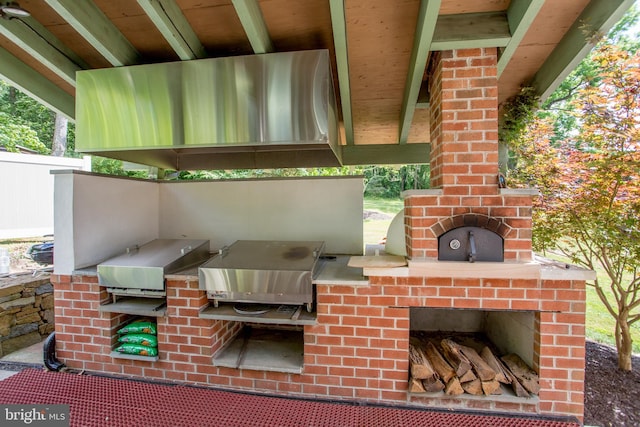 view of patio / terrace featuring exterior kitchen and a grill