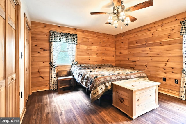 bedroom with dark hardwood / wood-style floors, ceiling fan, and wood walls