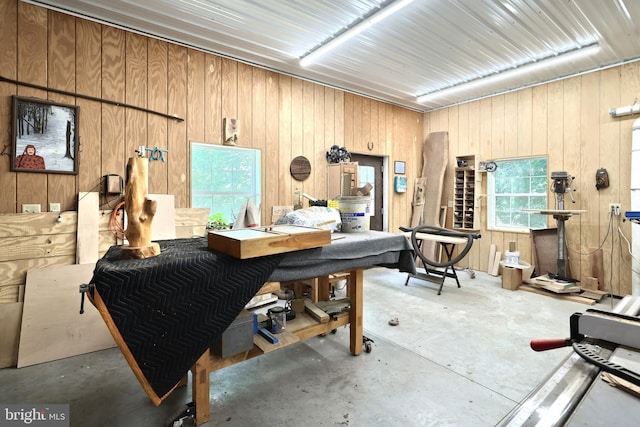 miscellaneous room with wood walls and concrete flooring