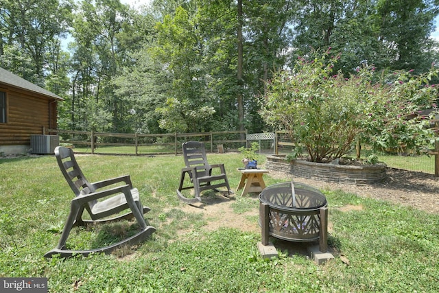 view of yard featuring cooling unit and a fire pit